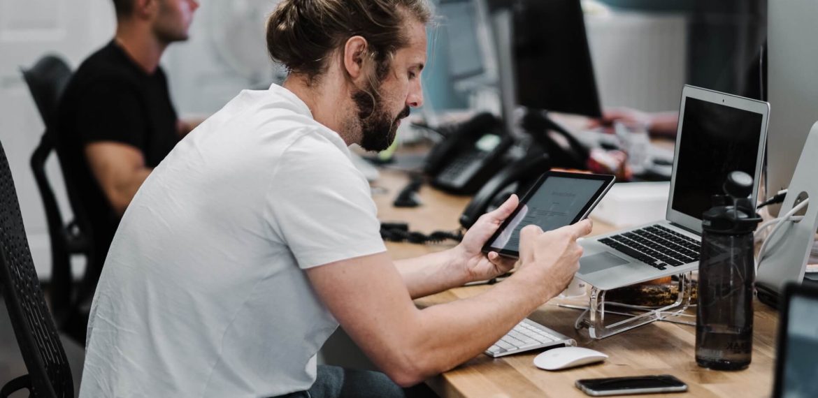 Young Men Working on Computers and Tablets for Managed IT Services in Carlsbad, CA