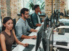 Group of People Sitting at a Long Desk with Computers for Business IT Services in Oceanside, CA